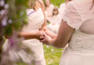 Bride holding hands with her bridesmaid.
