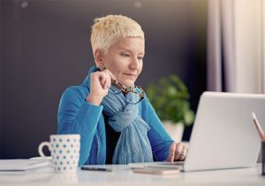 A woman sitting at a desk and using a laptop