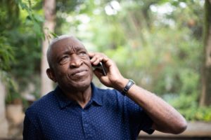 An elderly man talking on a mobile phone.