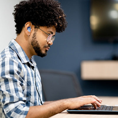 Hearing impaired man working on laptop at office